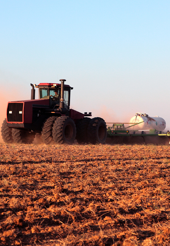 Tractor applying fertilizer to field
