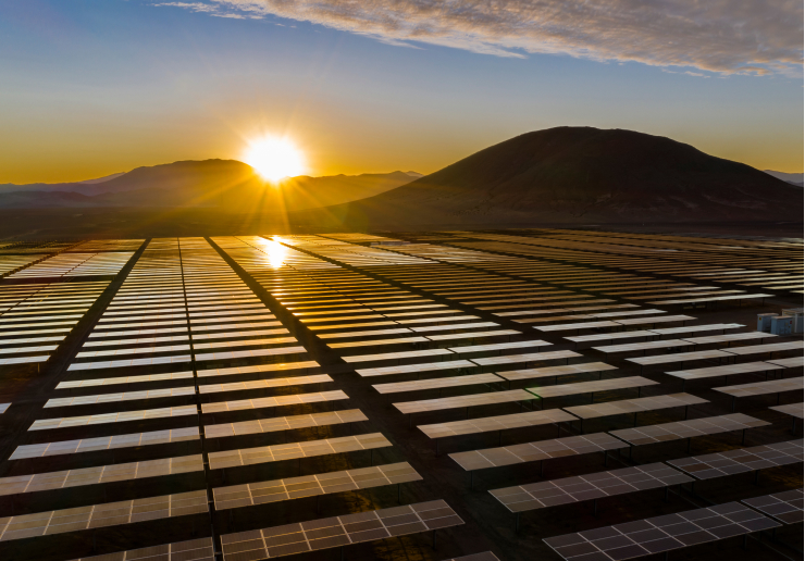 Solar Energy ground panels with sunrise on mountain line